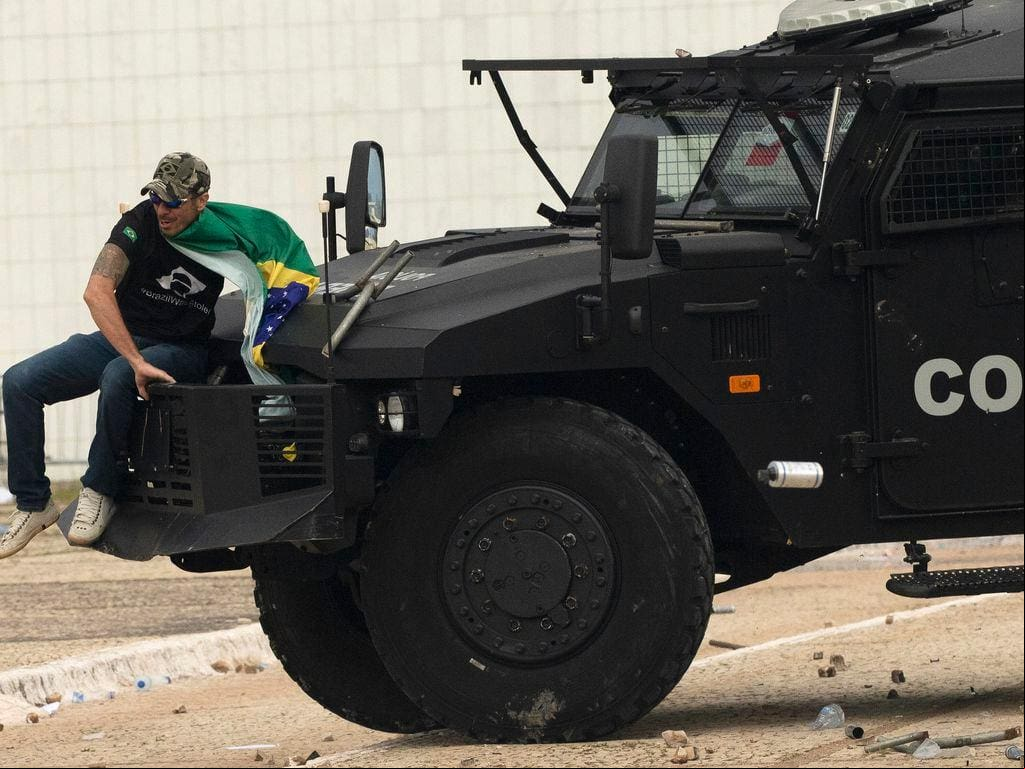 Extremista sobe em carro de choque da Policia Federal que faz a segurança próximo ao prédio do STF, durante os atos criminosos de 8 de janeiro
