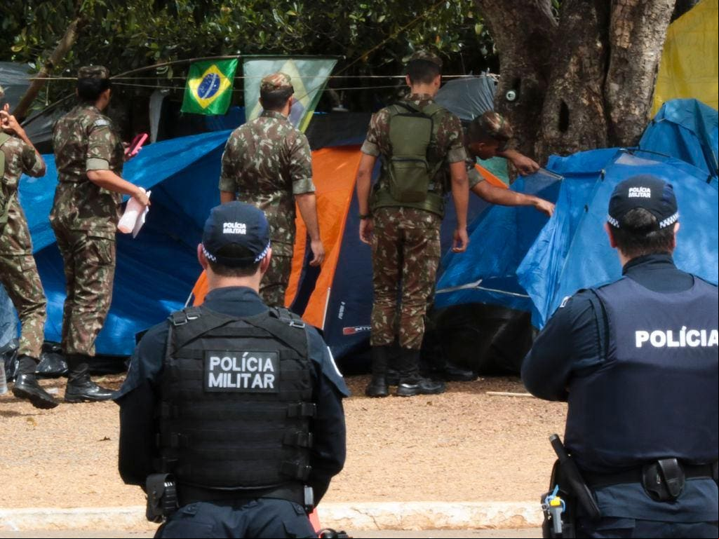 Homens e mulheres da Polícia Militar e do Exército Brasileiro desmontam o acampamento bolsonarista em frente do QG, um dia após a frustrada tentativa de derrubada do governo Lula