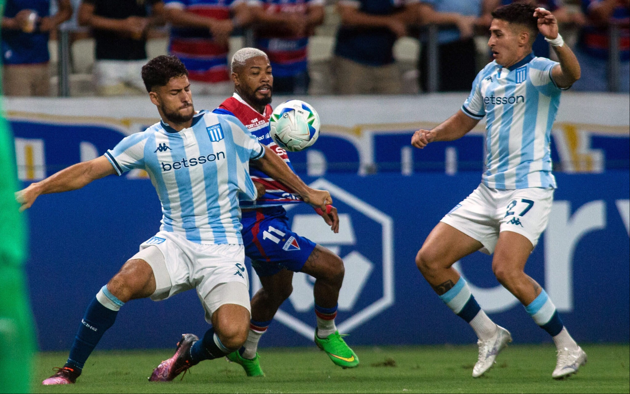 Marinho entre Marco Di Cesare e Gabriel Rojas em Fortaleza x Racing, pela Copa Libertadores (Foto: Thiago Gadelha/AFP)