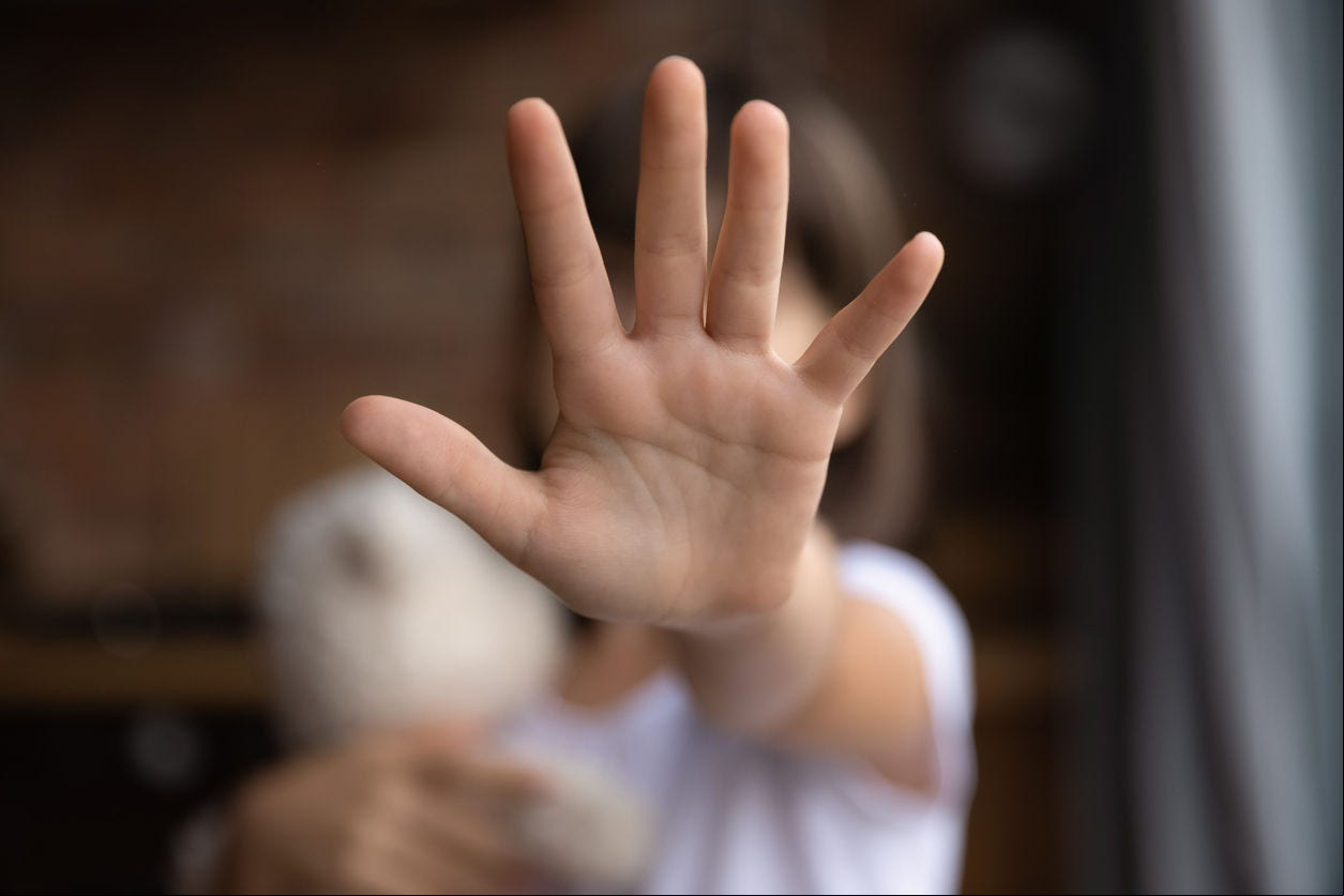 Crop close up of little girl child stretch hand show no gesture protest against domestic violence. Small teen child stand against discrimination or school abuse. Childhood problem, voice concept.